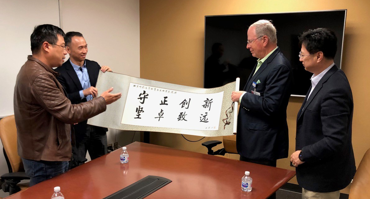 Professors GuoFeng Qu and ShaoJun Lyu , of Beijing Normal University, present a banner with their college motto – "Steadfastness and Innovation, Resilience and Future" – to Dr. Irving Kron , interim dean of the UA College of Medicine – Tucson, and UA lib Professors GuoFeng Qu and ShaoJun Lyu , of Beijing Normal University, present a banner with their college motto – "Steadfastness and Innovation, Resilience and Future" – to Dr. Irving Kron , interim dean of the UA College of Medicine – Tucson, and UA lib