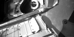 (Click to enlarge) This view from the Robotic Arm Camera on the Phoenix Mars Lander shows partial opening of doors to one of the tiny ovens of the Thermal and Evolved-Gas Analyzer. Each oven has a pair of spring-loaded doors. Near the center of the image, the partial opening of a pair of doors reveals a screen over the opening where a soil sample will be delivered. The door to the right is fully opened and the one to the left is partly deployed. The doors are 10 centimeters (4 inches) long. The opening is 4 centimeters (1.5 inches) wide. Tests on the Phoenix testbed at the UA indicate that a soil sample could be delivered into the oven through the partially opened doors. Engineers are also exploring possibilities for opening the doors more completely. This image was taken during Phoenix's eighth Martian day, Monday.
Partially Opened Oven on Phoenix