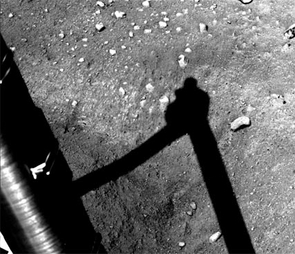 The Phoenix Mars Lander's Surface Stereo Imager captured a sequence of two images on Sols 6 and 7 – the sixth and seventh days of the mission, Sunday and Monday. Both images show an area to the west of the digging site informally known as "Knave of Hearts." In the second image (above), a small handful of Martian soil that has been released from the Robotic Arm to the surface is between Phoenix's arm, lower left, and the arm's shadow. The released soil is darker than the surrounding soil. Scoopful of Martian Soil After Release
