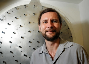 (Click to enlarge) A prototype of the adaptive mirror can be seen behind study leader Michael Hart. Controlled by a computer, the actuators warp the mirror ever so slightly to cancel out atmospheric blurring. (Photo credit: Norma Jean Gargasz / UANews) (Click to enlarge) A prototype of the adaptive mirror can be seen behind study leader Michael Hart. Controlled by a computer, the actuators warp the mirror ever so slightly to cancel out atmospheric blurring. (Photo credit: Norma Jean Gargasz / UANews)