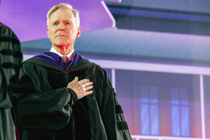 Commencement keynote speaker Ray Mabus stands at attention during the singing of the national anthem. (Photo: John de Dios/UANews) Commencement keynote speaker Ray Mabus stands at attention during the singing of the national anthem. (Photo: John de Dios/UANews)