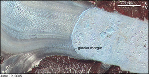 This satellite image shows Greenland’s Helheim glacier where it meets the sea. The glacier is on the left. Large and small icebergs pack the narrow fjord in the right part of the images. Bare ground appears brown or tan, while vegetation appears in shades of red. The Advanced Spaceborne Thermal Emission and Reflection Radiometer on NASA’s Terra satellite took the image in June 2005. (Photo credit: NASA images created by Jesse Allen, Earth Observatory, using data provided courtesy of NASA/GSFC/METI/ERSDAC/JAROS, and the U.S./Japan ASTER Science Team) This satellite image shows Greenland’s Helheim glacier where it meets the sea. The glacier is on the left. Large and small icebergs pack the narrow fjord in the right part of the images. Bare ground appears brown or tan, while vegetation appears in shades of red. The Advanced Spaceborne Thermal Emission and Reflection Radiometer on NASA’s Terra satellite took the image in June 2005. (Photo credit: NASA images created by Jesse Allen, Earth Observatory, using data provided courtesy of NASA/GSFC/METI/ERSDAC/JAROS, and the U.S./Japan ASTER Science Team)