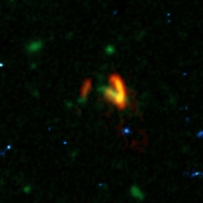 A composite image showing ALMA data (red) of the two galaxies of SPT0311-58. These galaxies are shown over a background from the Hubble Space Telescope (blue and green). The ALMA data show the two galaxies' dusty glow. The image of the galaxy on the right is distorted by gravitational lensing. The nearer foreground lensing galaxy is the green object between the two galaxies imaged by ALMA. (Credit: ALMA (ESO/NAOJ/NRAO), Marrone, et al.; B. Saxton (NRAO/AUI/NSF); NASA/ESA Hubble) A composite image showing ALMA data (red) of the two galaxies of SPT0311-58. These galaxies are shown over a background from the Hubble Space Telescope (blue and green). The ALMA data show the two galaxies' dusty glow. The image of the galaxy on the right is distorted by gravitational lensing. The nearer foreground lensing galaxy is the green object between the two galaxies imaged by ALMA. (Credit: ALMA (ESO/NAOJ/NRAO), Marrone, et al.; B. Saxton (NRAO/AUI/NSF); NASA/ESA Hubble)
