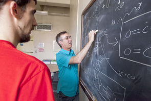 Sanov draws out the chemical reaction and formula of the long elusive ethylenedione (OCCO) four-atom compound to team members Andrew Dixon, a doctoral student in chemistry, and Tian Xue, an undergraduate majoring in chemistry. The students were instrumental to Sanov’s research on discovering proof of the long-elusive compound. (Photo: John de Dios/UANews) Sanov draws out the chemical reaction and formula of the long elusive ethylenedione (OCCO) four-atom compound to team members Andrew Dixon, a doctoral student in chemistry, and Tian Xue, an undergraduate majoring in chemistry. The students were instrumental to Sanov’s research on discovering proof of the long-elusive compound. (Photo: John de Dios/UANews)