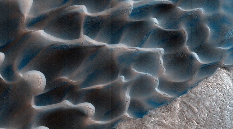 The retreat of Mars' polar cap of frozen carbon dioxide during the spring and summer generates winds that drive the largest movements of sand dunes observed on the red planet. (Image: NASA/JPL/University of Arizona/USGS)