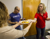 A volunteer handing off a full plate of chorizo and eggs. (Photo: Kyle Mittan/University Communications)