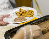 The Budget Office held its 18th annual chorizo breakfast, offering chorizo, eggs, beans and tortillas for $5 a plate. The event raised $2,350 for the National Alliance on Mental Illness – Southern Arizona. (Photo: Kyle Mittan/University Communications) Refried beans being scooped onto a plate with chorizo and eggs.