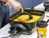 A hand stirs chorizo and eggs in an electric skillet. (Photo: Kyle Mittan/University Communications)