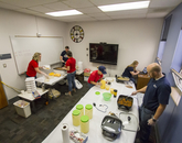 Volunteers cooking chorizo and eggs, and loading plates with chorizo, eggs, beans and cheese. (Photo: Kyle Mittan/University Communications)