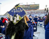 Maya Wallace, an agricultural technology, management and education graduate from Tucson, plans to attend graduate school in the fall. Her mortarboard is decorated with the finishing command she uses with her trained border collies at home. (Photo: John de Dios/UANews) Maya Wallace, an agricultural technology, management and education graduate from Tucson, plans to attend graduate school in the fall. Her mortarboard is decorated with the finishing command she uses with her trained border collies at home. (Photo: John de Dios/UANews)