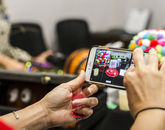 Someone using a cellphone to take a photo of a pumpkin decorated to resemble a gumball machine. (Photo: Kyle Mittan/University Communications)