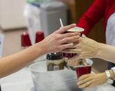 A hand passing a root beer float to someone. (Photo: Kyle Mittan/University Communications)