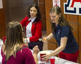 Volunteers standing at a table making and serving root beer floats. (Photo: Kyle Mittan/University Communications)