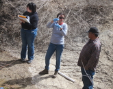 Ruby Sierra of the Environmental Health Sciences Transformative Research Undergraduate Experience program, Paloma Beamer and Arnold Clifford take a core sample in an agricultural field. Ruby Sierra of the Environmental Health Sciences Transformative Research Undergraduate Experience program, Paloma Beamer and Arnold Clifford take a core sample in an agricultural field.