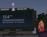 Kailyn Elizabeth Toussaint (on monitor), who graduated with a bachelor's degree in musical theater, leads the stadium in a rousing rendition of the national anthem. (Photo: John de Dios/UANews) Kailyn Elizabeth Toussaint (on monitor), who graduated with a bachelor's degree in musical theater, leads the stadium in a rousing rendition of the national anthem. (Photo: John de Dios/UANews)