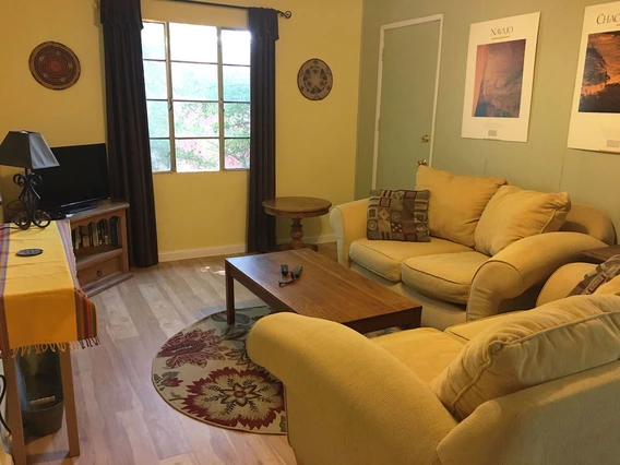 living room with couches, a coffee table, television and art on the walls