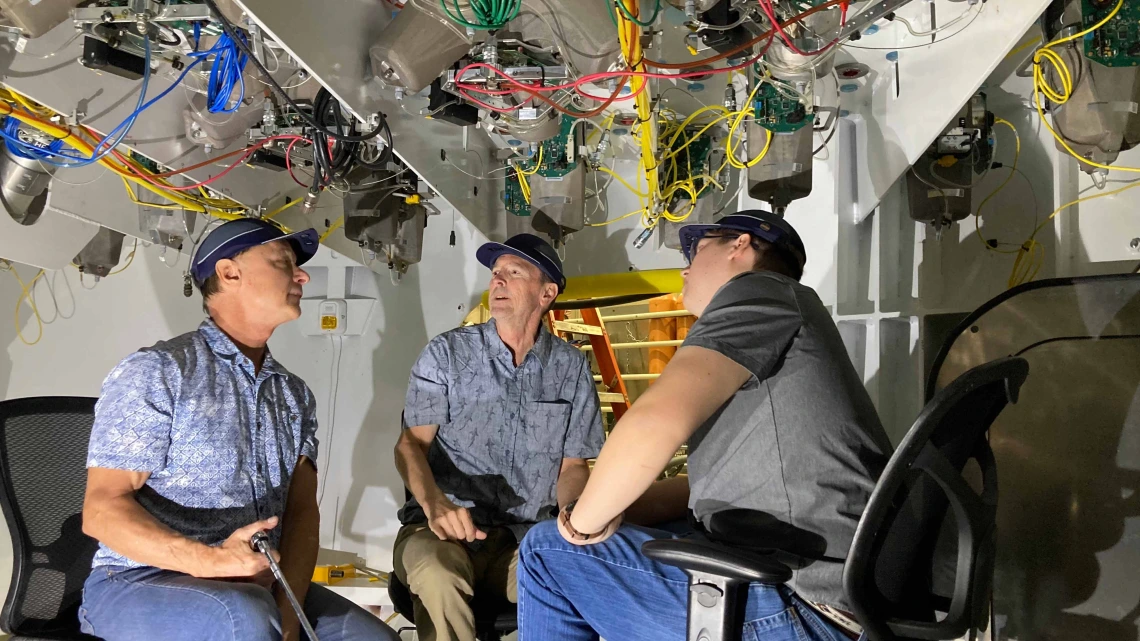 Buddy Martin (center) inspects components inside the support cell with Giant Magellan Telescope engineers Tomas Krasuski (left) and Colby Gottschalk (right).