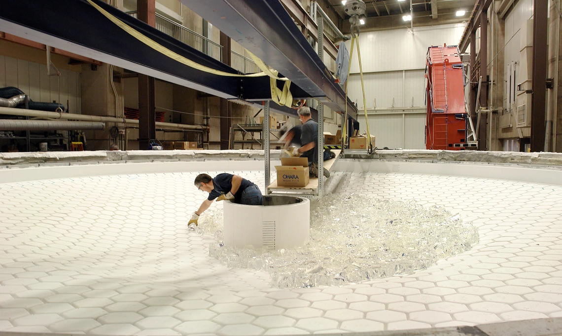 Technicians at the Richard F. Caris Mirror Lab load chunks of glass onto the honeycomb mold during fabrication of Rubin Observatory’s combined primary/tertiary mirror.