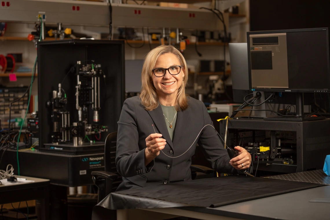 Jennifer Barton in a lab holding an ovarian cancer detection falloposcope