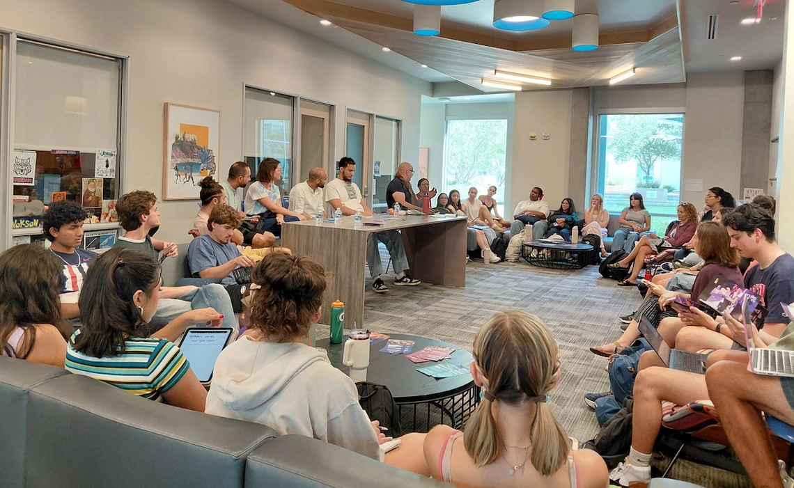 Students sit in a large circle in a campus lounge as members of the Mohamed Abozekry Sextet speak from a table at the front of the room. The musicians and professor lead a discussion about Arabic instruments and jazz fusion as part of a Contemporary Muslim Societies class.
