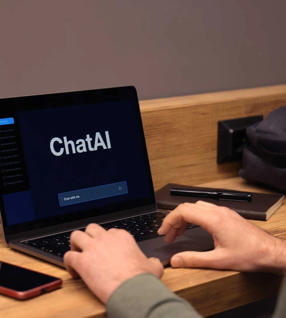hands typing on a keyboard while the computer screen reads "chatAI"