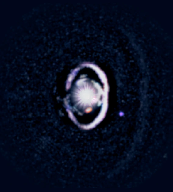 The star, WISPIT 2, appears a bright spot in the center, surrounded by a white, bright ring of dust. Two small dots indicate the growing protoplanets in the system. 