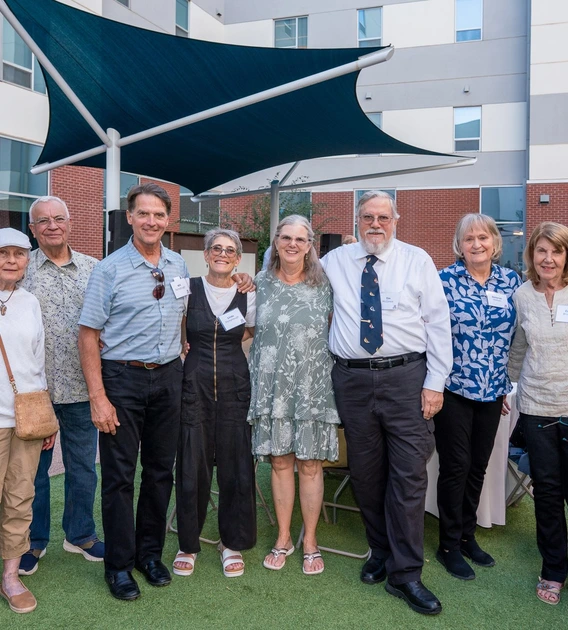 Several men and women stand together in a courtyard.