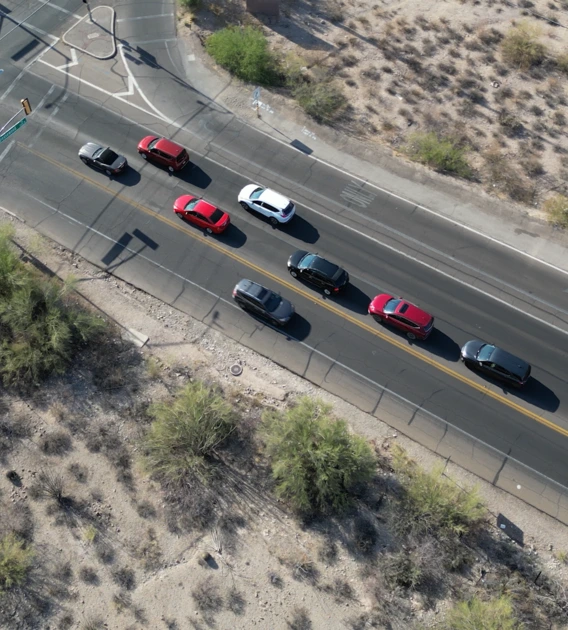 an overhead view of an intersection with cars with a person sitting near the intersection in a lawn chair