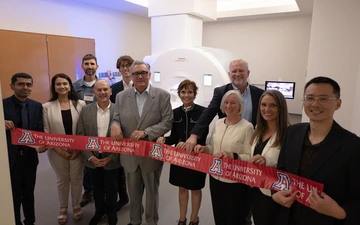 Several people gathered for a ribbon cutting for MRI machine