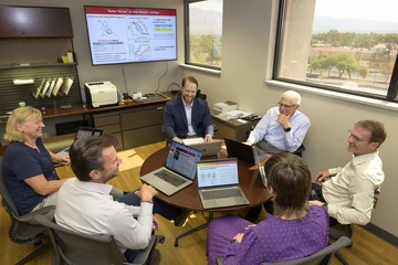 U of A researchers with computers in office space.