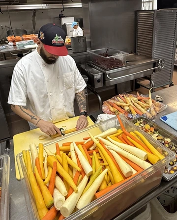 Arizona Dining Lead Cook Ernesto Salcido prepares carrots for Thanksgiving Dinner To-Go meals.