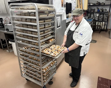 Arizona Dining Executive Sous Chef Manja Blackwood pulls out a tray of freshly-baked orange cranberry bread made for the Thanksgiving Bake Sale