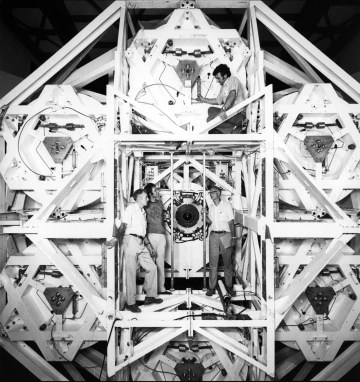 The Multiple Mirror Telescope 40 years ago as seen from the back. Standing at the center of the telescope are (from left) Nathaniel Carleton of the Smithsonian Astrophysical Laboratory, Neville "Nick" Woolf, professor emeritus in Steward Observatory, who 