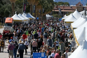 a large crowd of people and several white tents fill the university of arizona campus during the tucson festival of books