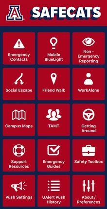 Screenshot of the SafeCats mobile app home screen on a smartphone. The University of Arizona logo appears at the top above the word “SafeCats” in white text on a red background. Below are 16 red square buttons with white icons and labels, arranged in a grid. Features include: Emergency Contacts, Mobile BlueLight, Non-Emergency Reporting, Social Escape, Friend Walk, WorkAlone, Campus Maps, TAMT, Getting Around, Support Resources, Emergency Guides, Safety Toolbox, Push Settings, UAlert Push History, and About