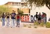 students walking past the U of A main library in front of a large "Bear Down" sign