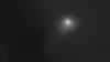 Comet 3I/ATLAS is visible as a smudgy, white speck with a diffuse halo around it against jet-black background of space. 