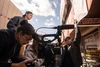 Film students surround a camera and film a scene outside of a restaurant.