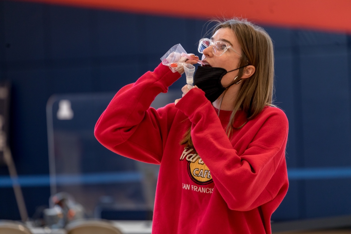 young woman taking a saline gargle test