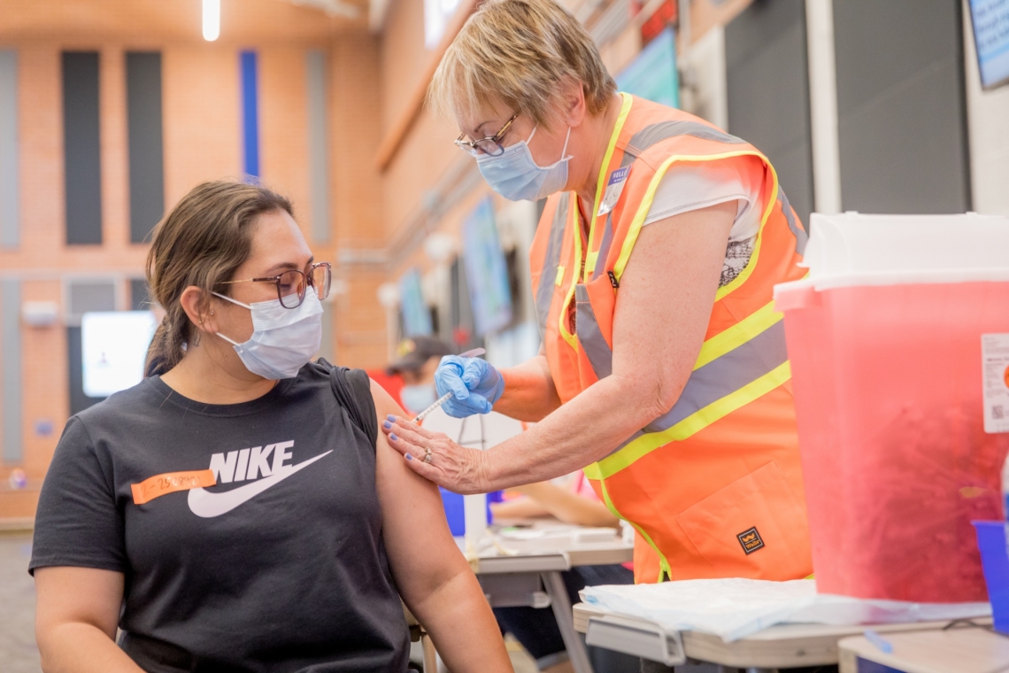 a young woman receives a vaccine