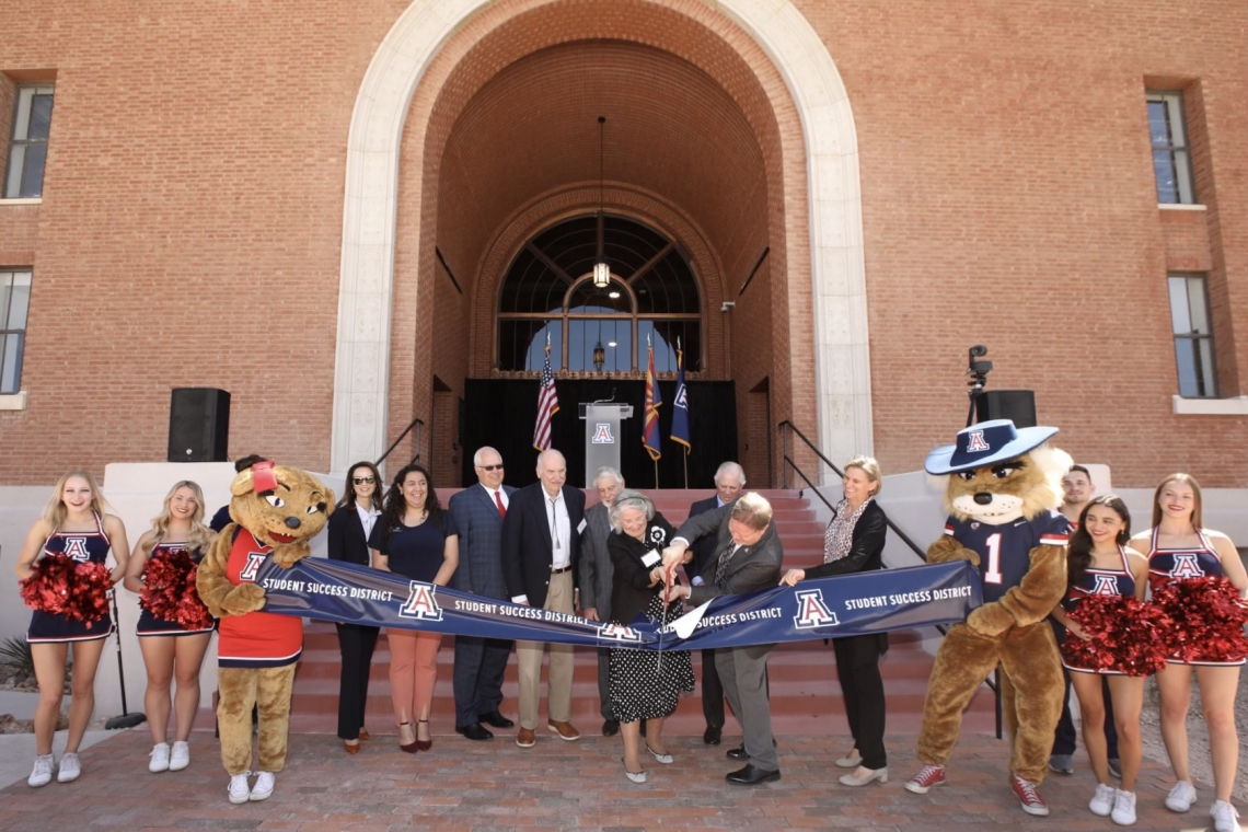 people cutting a ribbon outside the student success district