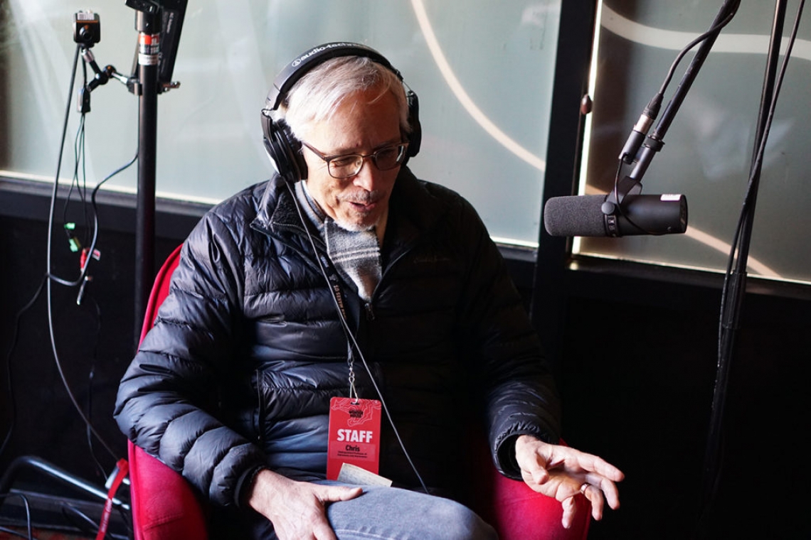 man wearing headphones in front of a microphone