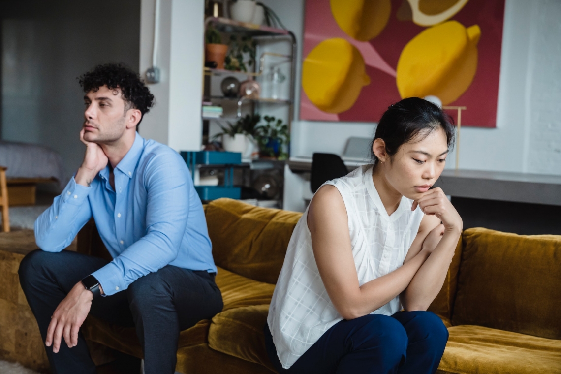 two people facing away from each other on a couch