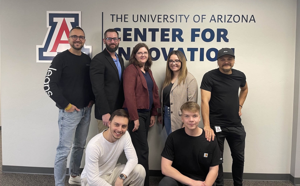 seven people posing in front of a university of arizona center for innovation sign