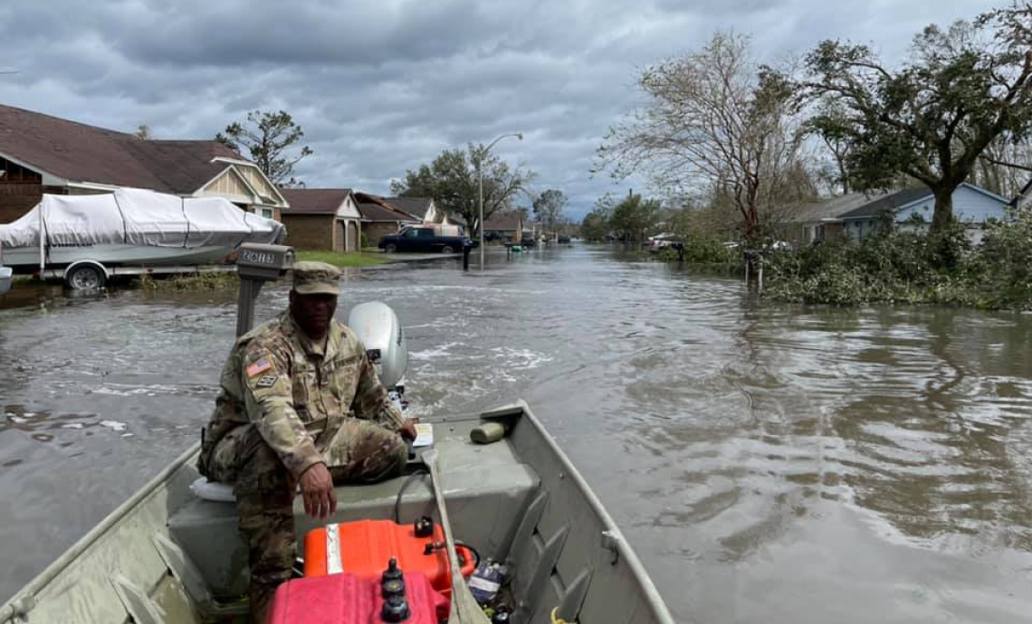 Man on a boat in a flooded neighborhood. Man on a boat in a flooded neighborhood.