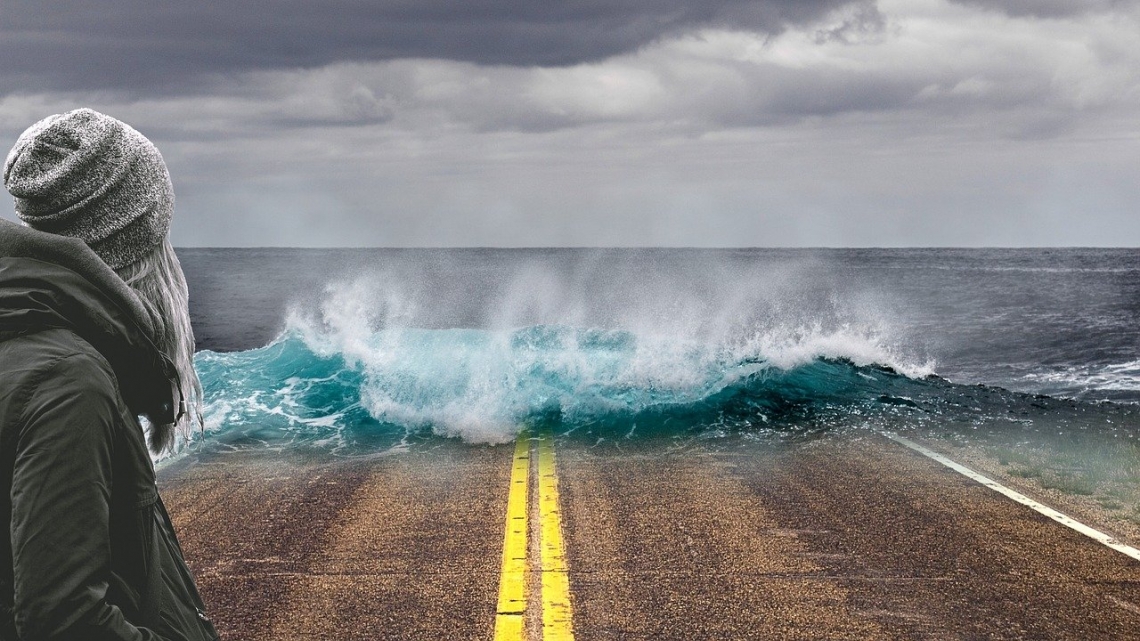 Sea levels are expected to rise under a warming climate Waves breaking over a road