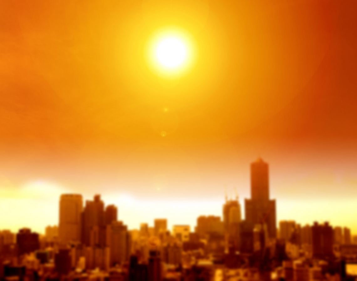the sun casting an orange glow over a blurry city skyline