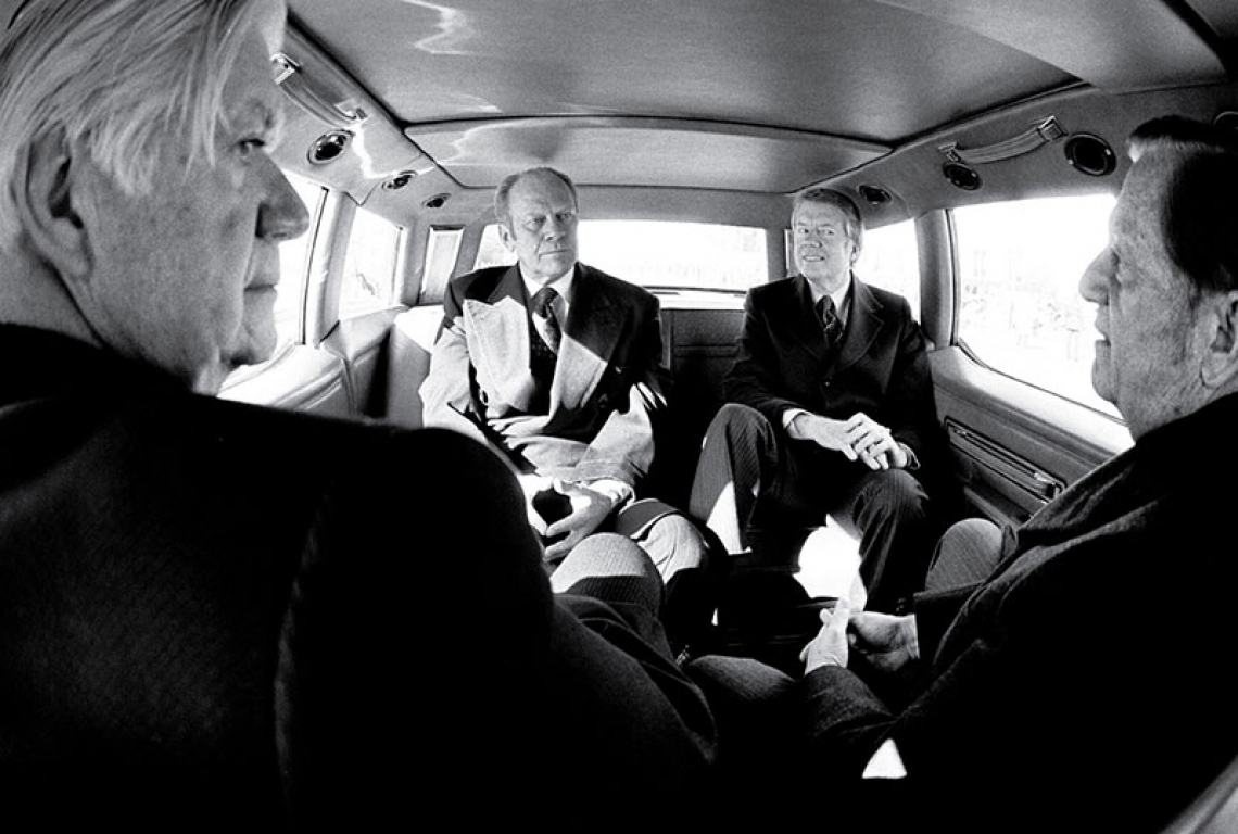 A black and white photograph of President Gerald Ford, President-Elect Jimmy Carter, Senator Howard Cannon and Speaker of the House Tip O'Neill on their way to Carter's inauguration