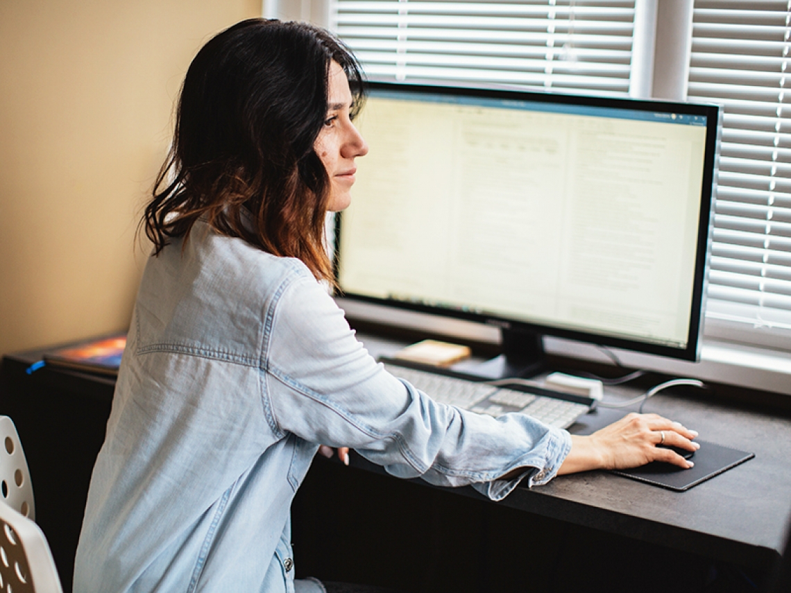 Woman working at computer looks to the side