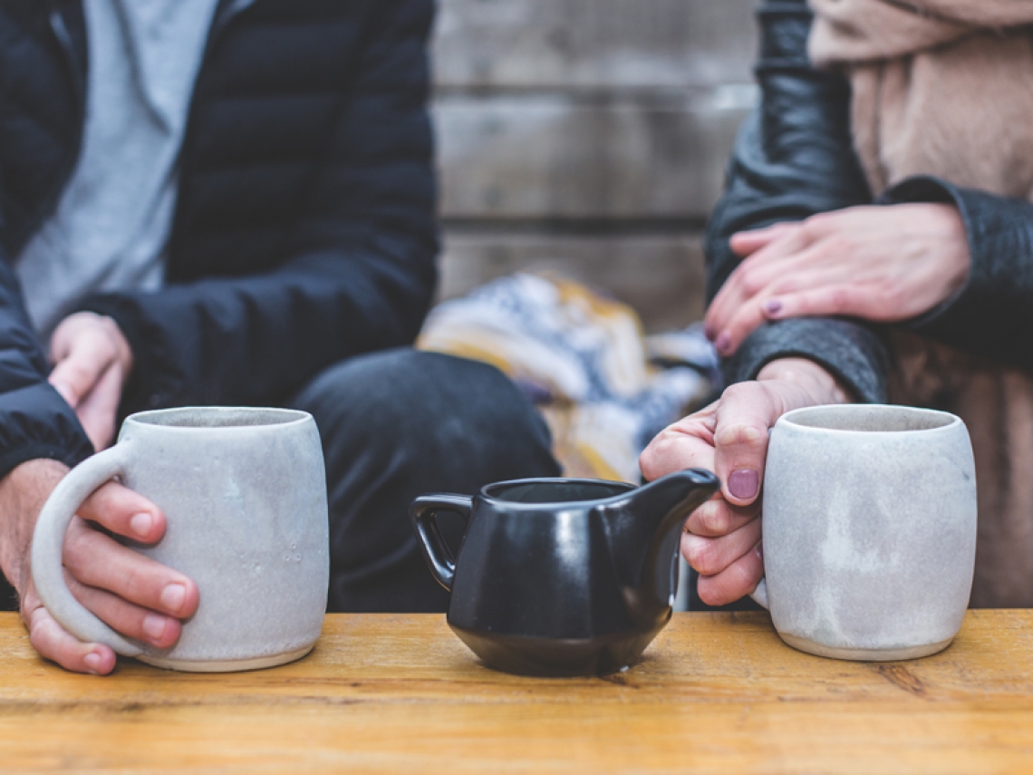 “Two people drinking tea and talking”